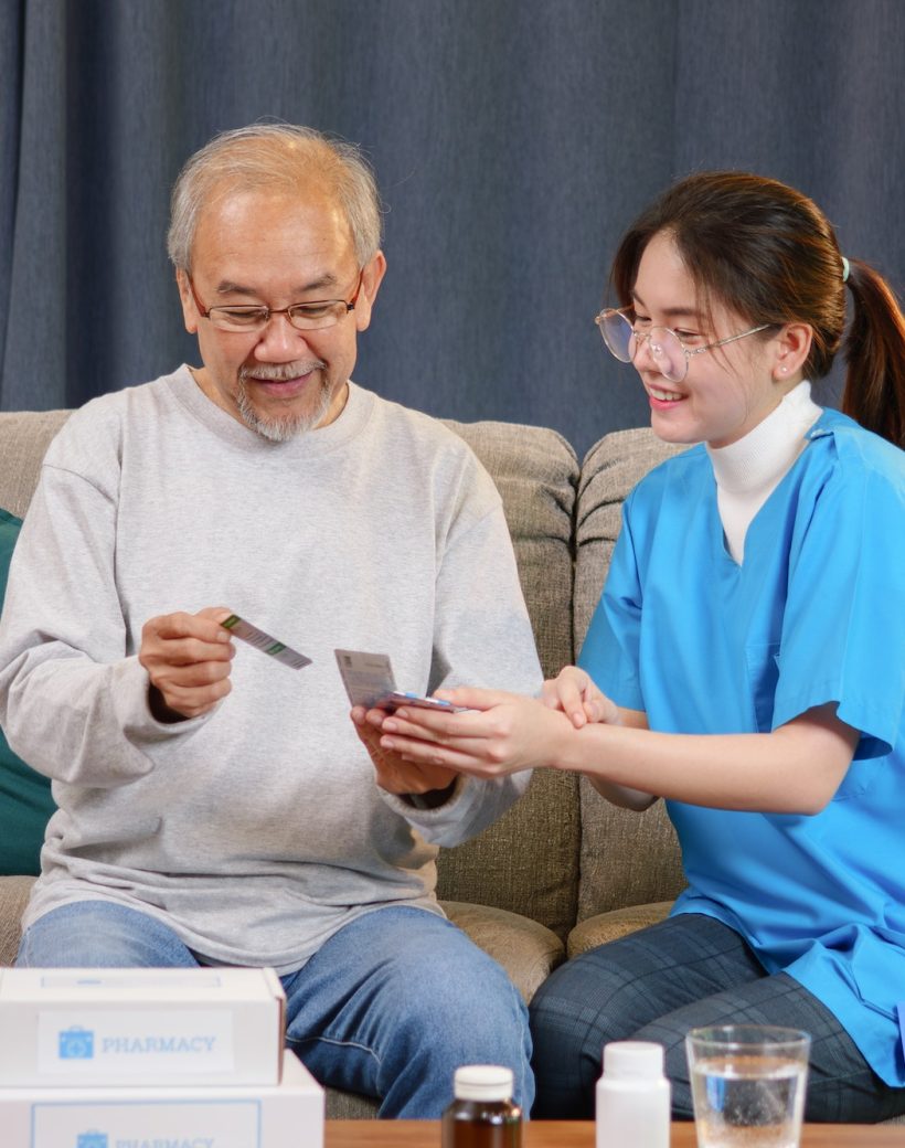 Caregiver nurse taking care of elderly grandfather at home